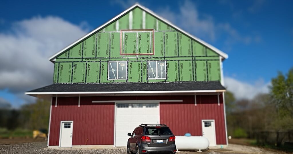 Steel board and batten barn siding installation in progress Manitou Beach Michigan