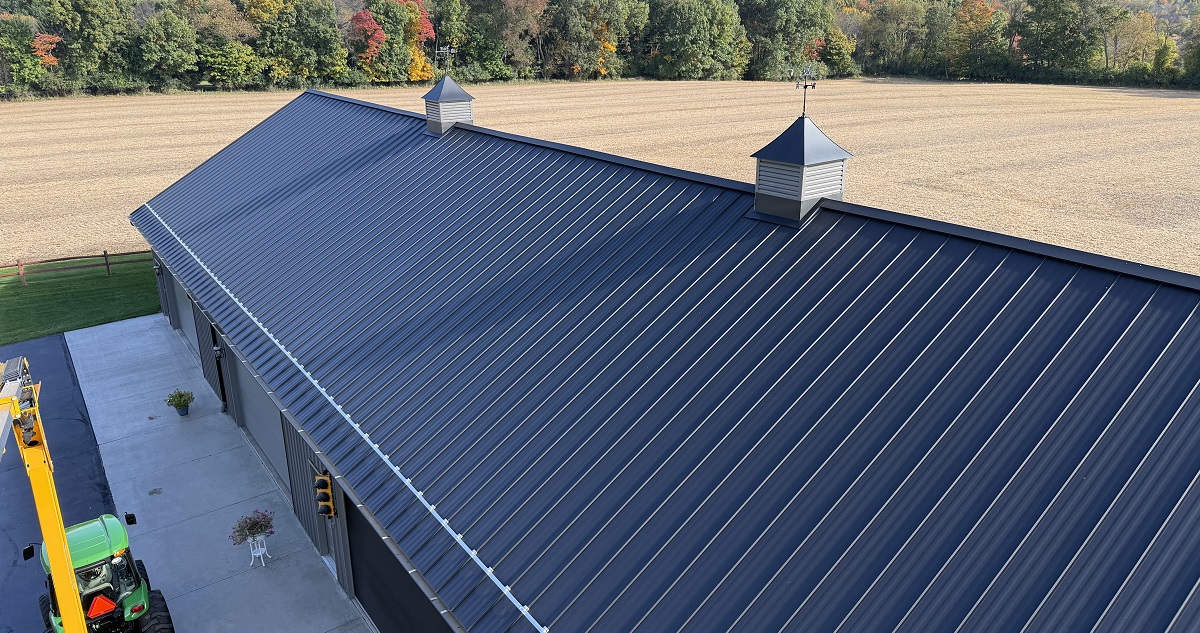 Black Crinkle standing seam metal roof on a Hillsdale County outbuilding with cupolas and snow retention